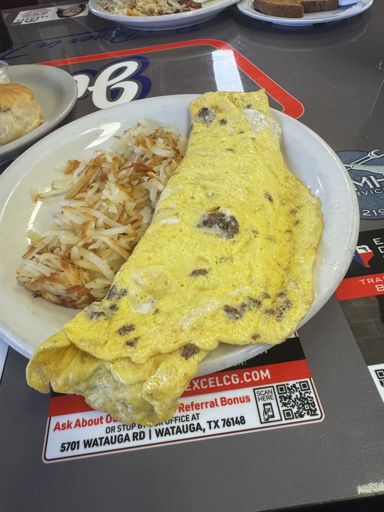 A large diner omelet served with hash browns and a biscuit